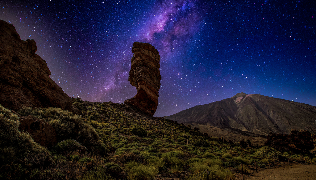 La VÃa Láctea brilla sobre las montañas en una noche estrellada.